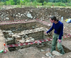 Arriba Sophie Gilotte muestra los restos encontrados; abajo dos jóvenes trabajando en la muralla./ MAM