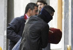 Dos agentes trasladan al pirata 'Abdu Willy' al Juzgado de Menores de Madrid. / AFP