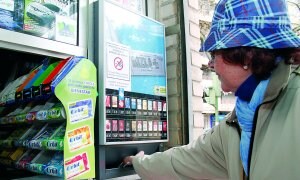 Una mujer compra tabaco a través de una máquina en un quiosco de Cánovas. ::
CHENCHO.