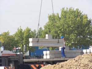 Obreros descargan los módulos que formarán la estructura. ::                             C. PINO