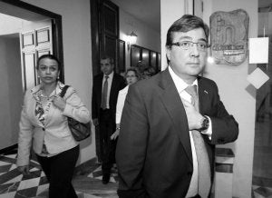 Fernández Vara pasa por delante del logotipo de Cáceres 2016 en al Ayuntamiento, donde se analizó el fututro del Consorcio. ::                             L. CORDERO.