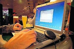 Un internauta se dispone a elegir una red wifi de entre las que capta su ordenador, mientras toma un aperitivo en una cafetería. ::                             JORGE REY
