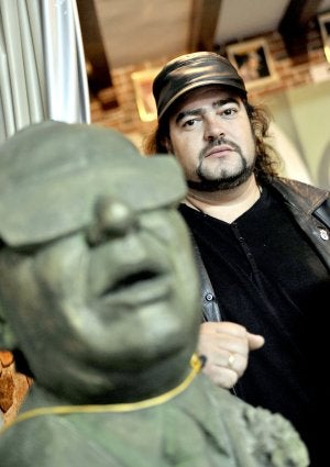 Miguel de Tena, de la nueva generación del flamenco extremeño, posa junto a una escultura de Porrina en su peña de Don Benito. ::                             ARNELAS