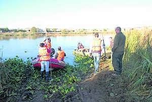 Varios voluntarios de Cruz Roja depositan el camalote. ::                             BRÍGIDO