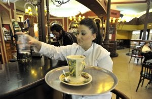 Una camarera recoge un vaso en una cafetería de Badajoz. ::                             J. V. ARNELAS