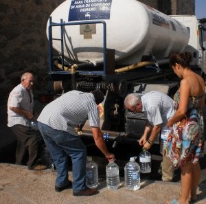 Vecinos de Esparragalejo cogen ayer agua del camión cisterna. ::                             S. G.