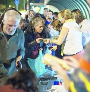 Una voluntaria ofrece comida a una persona necesitada en Barcelona. ::
VICENS GIMÉNEZ