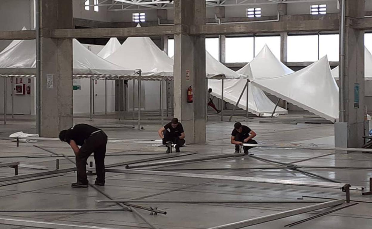 Los operarios preparan uno de los pabellones del recinto ferial 