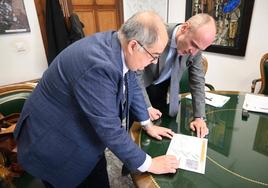 El alcalde y el gerente de la empresa analizan los planos de las viviendas