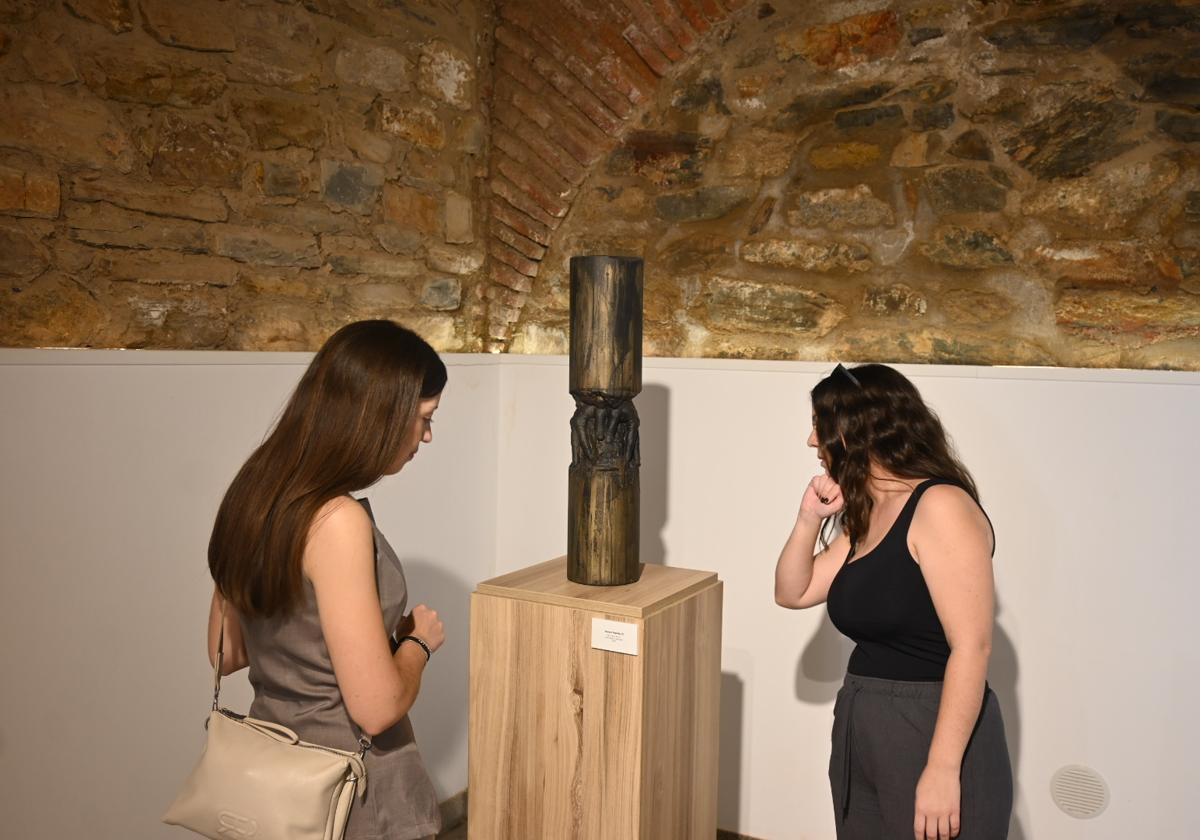 Dos visitates contemplan una de las obras del artista