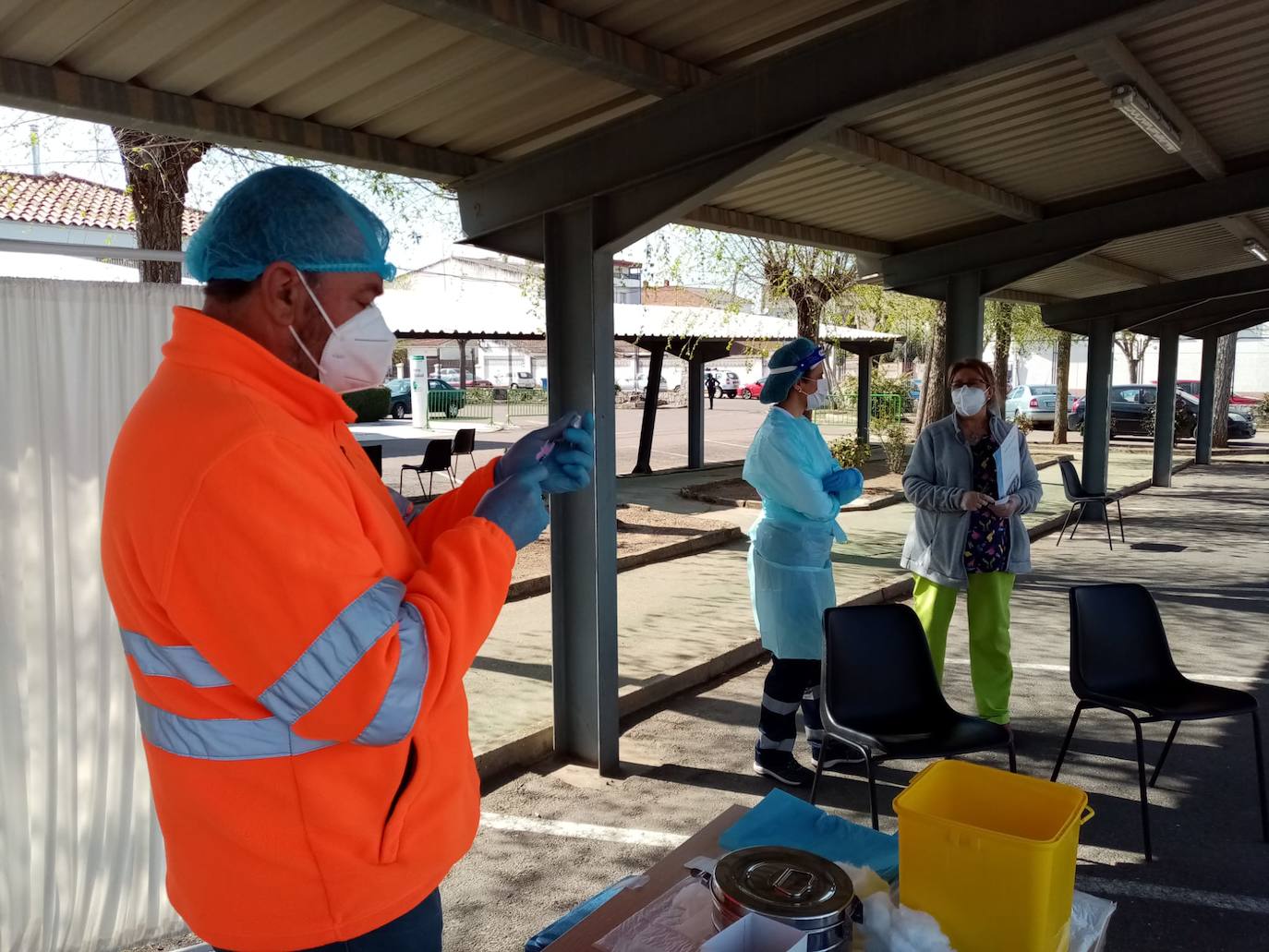 Sanitarios esperar para recibir a los mayores para la vacuna .