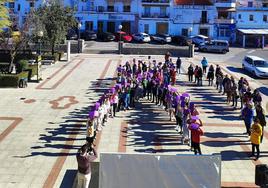 Un grupo de escolares formó u ngran lazo morado en la puerta del ayuntamiento.