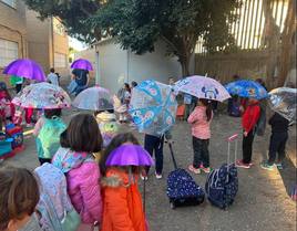 Padres y madres de alumnos del colegio Mare Nostrum, con paraguas abiertos para apoyar la causa.