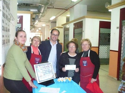 La ganadora del cheque de 100 euros del mercado lo dona para Cáritas