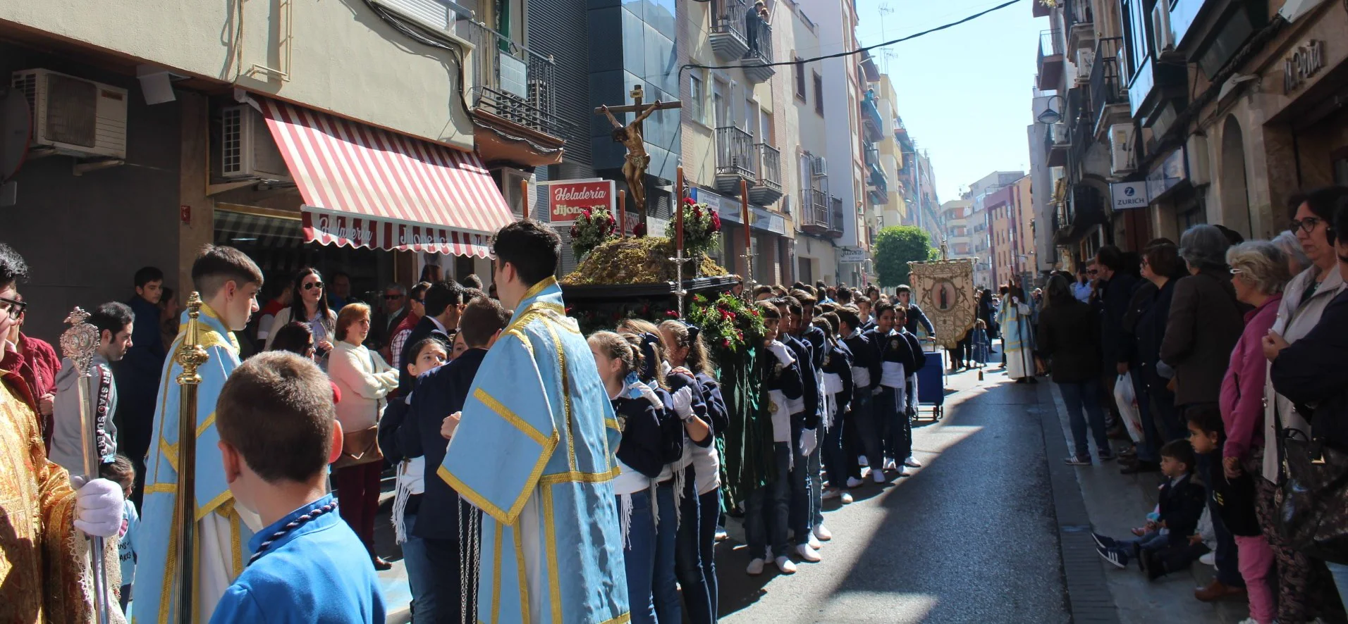 Pequeños costaleros y costalerias portan al Cristo del Calvario por la calle Ibáñez Marín. 