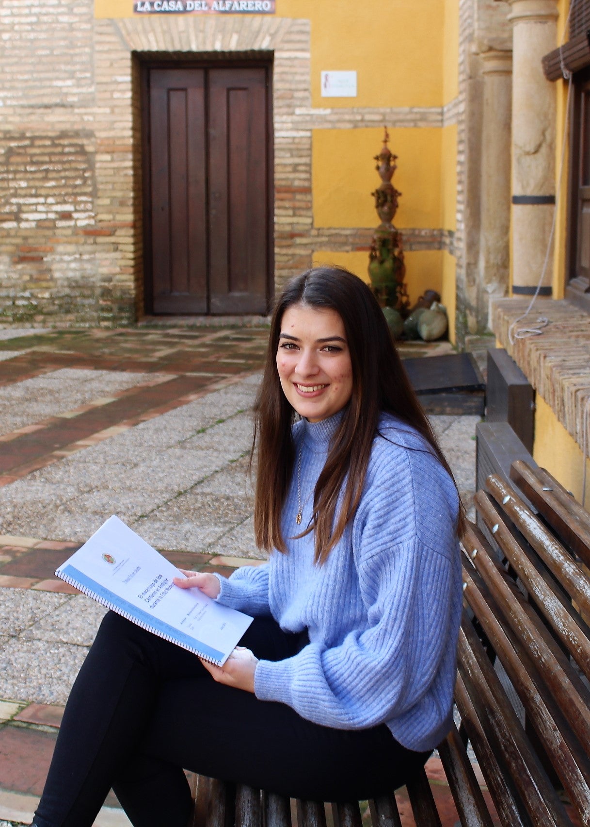 Montse posa en el Palacio de los Niños de Don Gome, como fondo la Casa del Alfarero. 