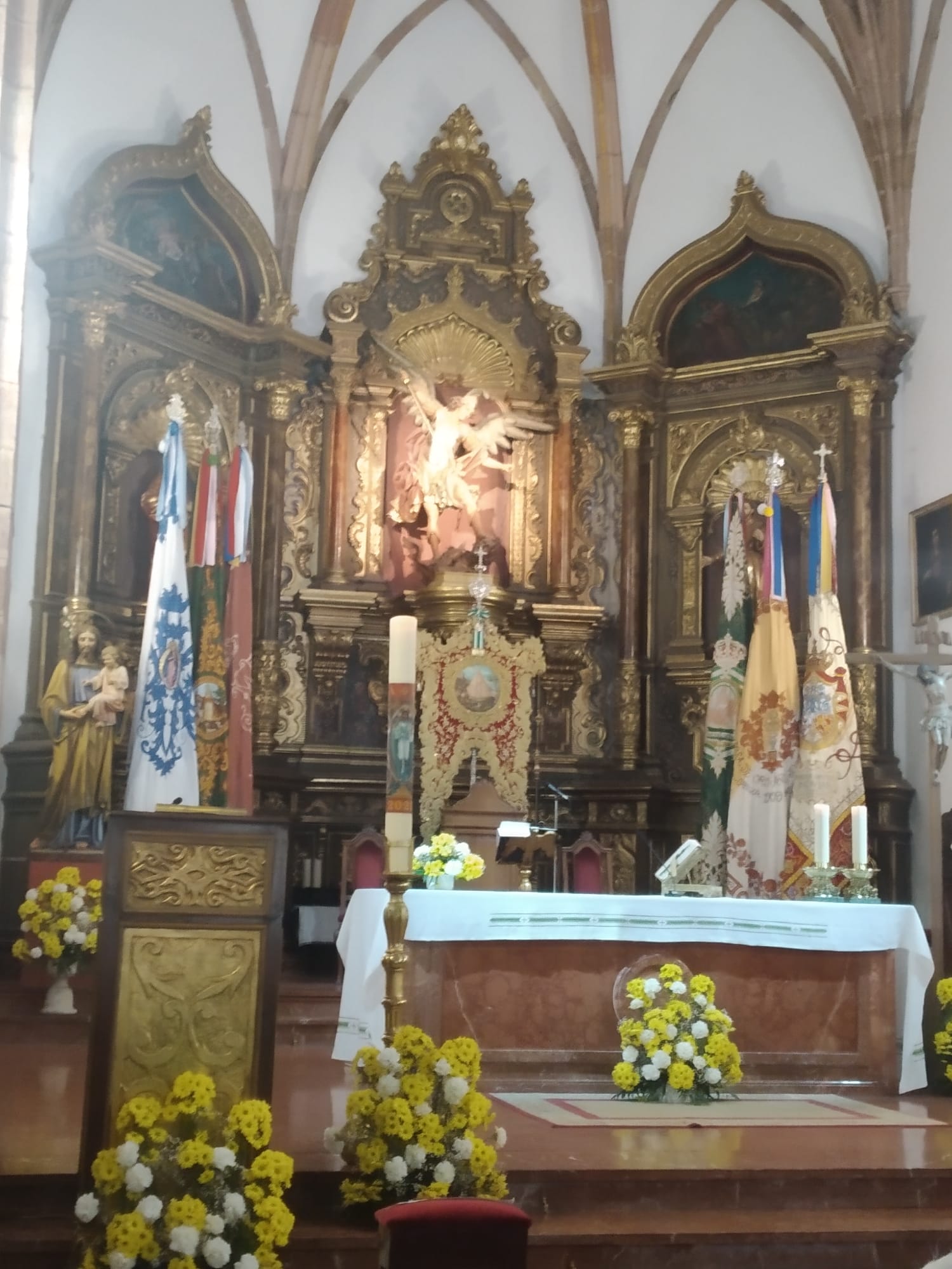 Banderas y estandarte de la Cofradía Matriz el pasado domingo en el altar de la iglesia de San Miguel Arcángel. 