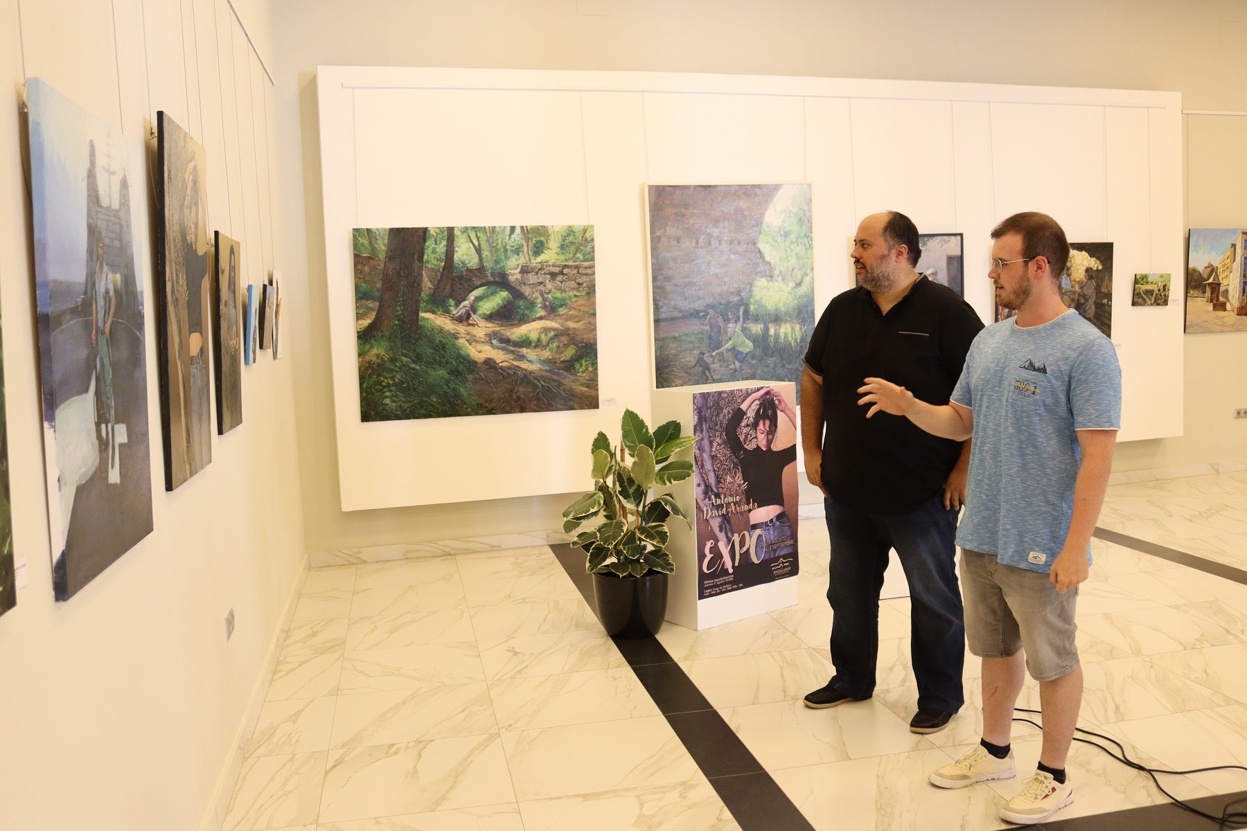 Juan Francisco Cazalilla y Antonio David Aranda contemplan los lienzos. 