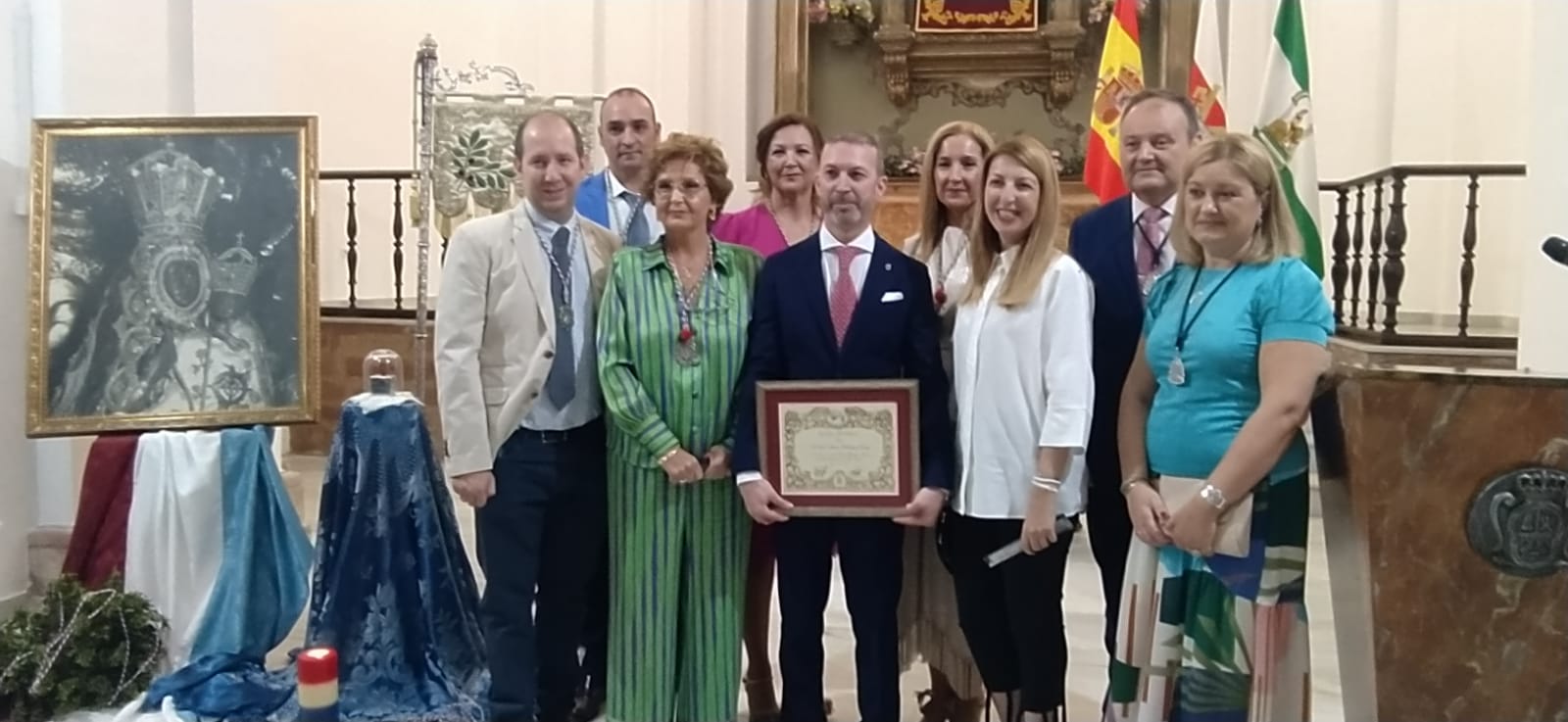 Juan Antonio Rodrígiuez posa con la placa rodeado de difectivos de la peña El Madroño y de autoridades. 