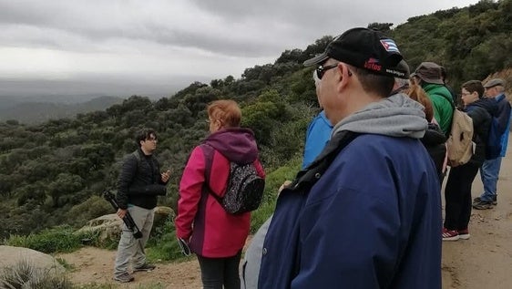 Un guía dirige a los participantes de la ruta en un avistamiento.