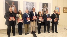 Responsables de la Hermandad, el Ayuntamiento y el IEG posan con los catálogos en la inauguración.