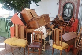 PROLIFERACIÓN DE MOBILIARIO AL LADO DE UN CONTENEDOR.