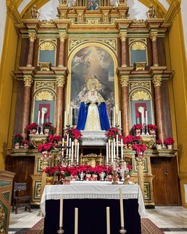 Los pascueros navideños adornan la imagen de la Virgen.