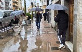 Vecinos se protegen de la lluvia en el reciente enjambre de borrascas.