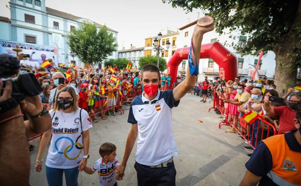 El medallista olímpico David Valero muestra su medalla desde el balcón del Ayuntamiento de Baza ante una plaza abarrotada de vecinos. 