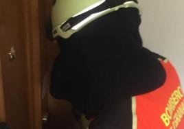 Un bombero abre la puerta del domicilio del fallecido.