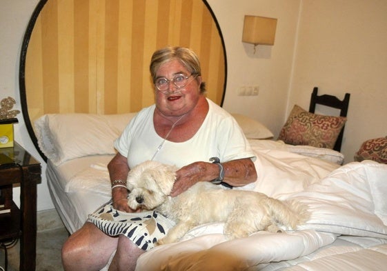 Raquel Aránega, con su perra Perla, en el dormitorio de su casa.
