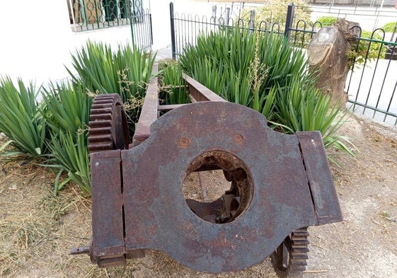 Parte de la grúa, oxidada en un pequeño vallado.