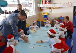 Entregando dominós de madera a los alumnos de las escuelas infantiles