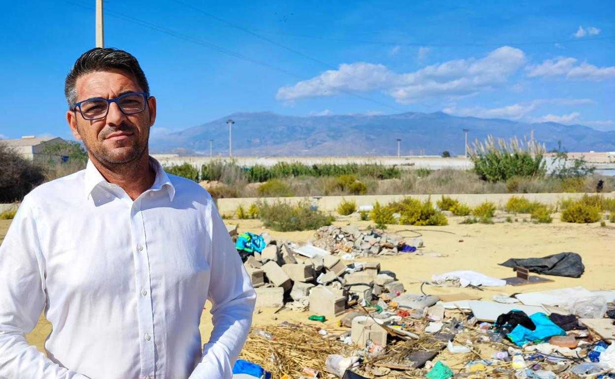 Rafael Bretones con el campo de fútbol de Matagorda convertido en vertedero, a sus espaldas. 
