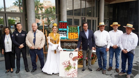Una mujer vestida de flamenca, junto a dos símbolos: las habas y el tocino por el cartel de San Marcos