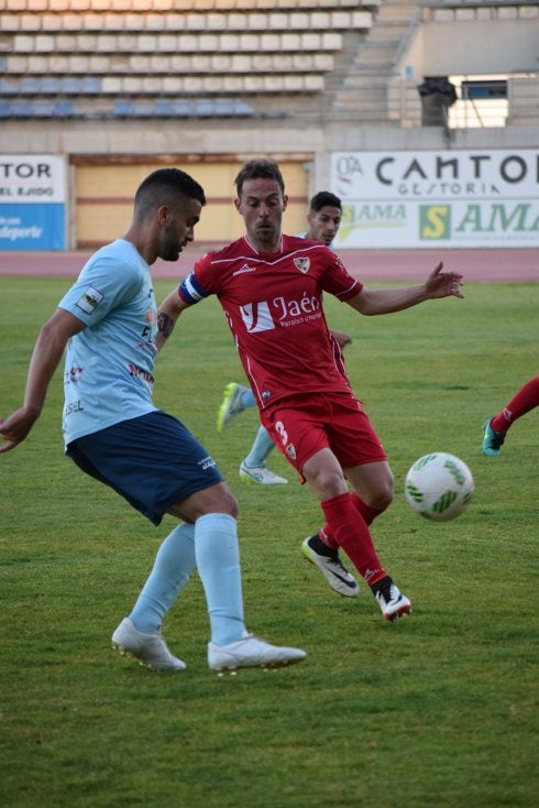Samu Corral da un pase en profundidad ante el lateral izquierdo linarense Higinio.