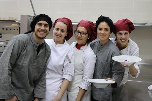 Los alumnos muestran dos de los platos cocinados en la escuela.