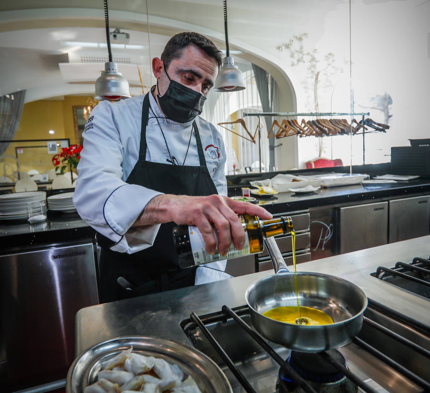 Imagen principal - Arriba, David Fernández, jefe de cocina de La Platea; debajo, aceites del Poniente granadino y la aceituna gordal en plena maduración..