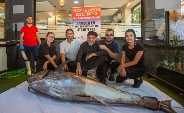 El equipo de cocina de Asador Curro posa junto al atún que prepararían de inmediato. 