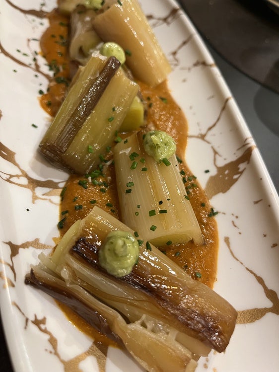 Los suculentos puerros confitados con salsa romesco y su picada de frutos secos de Restaurante Picón.