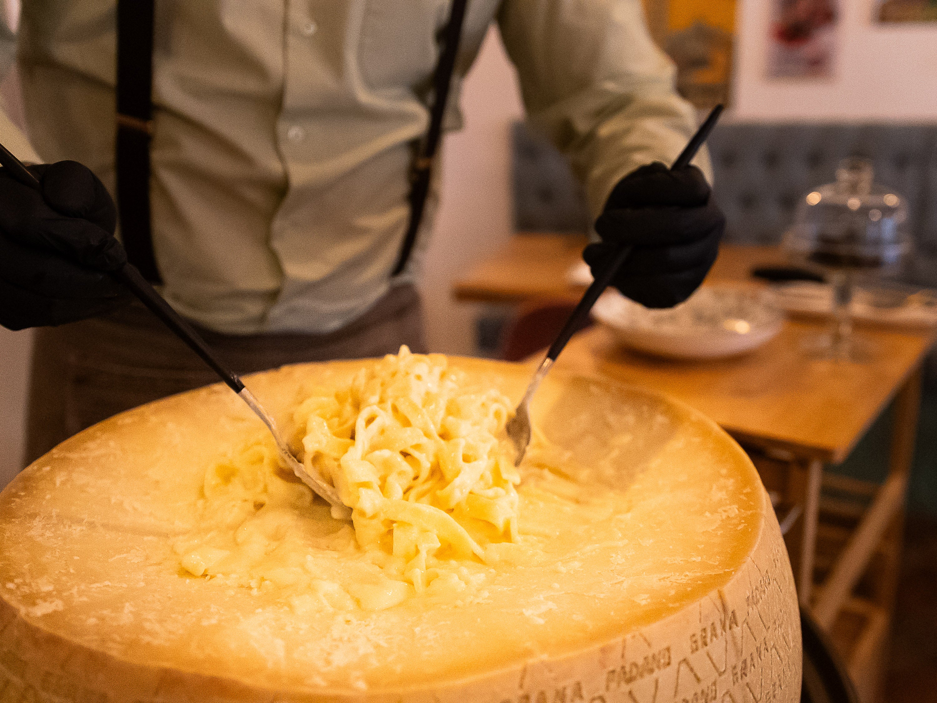 Los tagliatelle Alfredo se terminan en mesa en una rueda de Granada Padano.