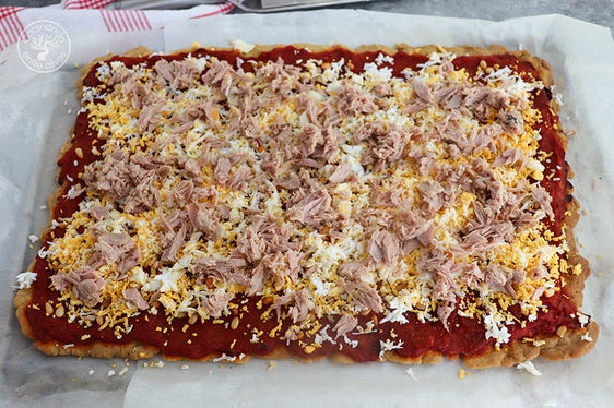 Coca de tomate, huevo y atún con pimiento y piñones