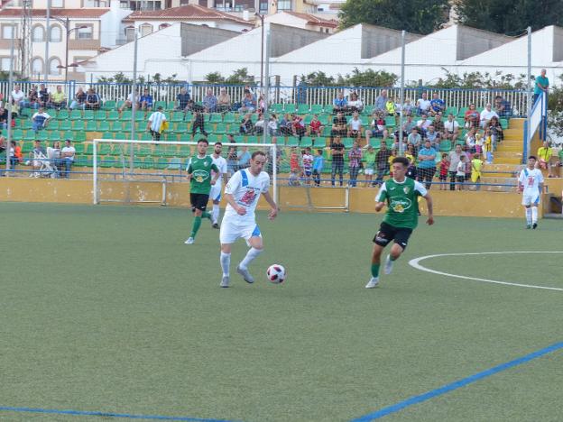 Alberto López trata de sacar un balón jugado en medio campo ante la presión de un rival.