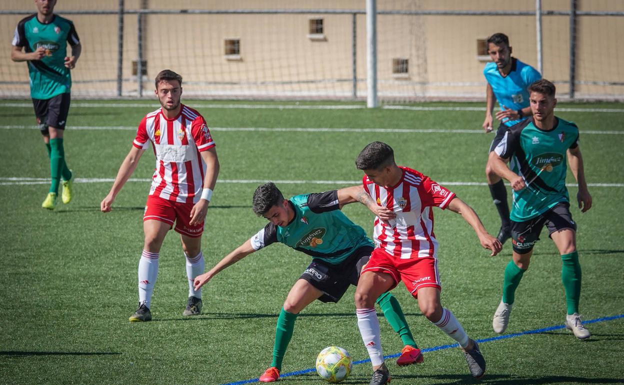 Un jugador del Huétor Vega trata de recuperar el balón.