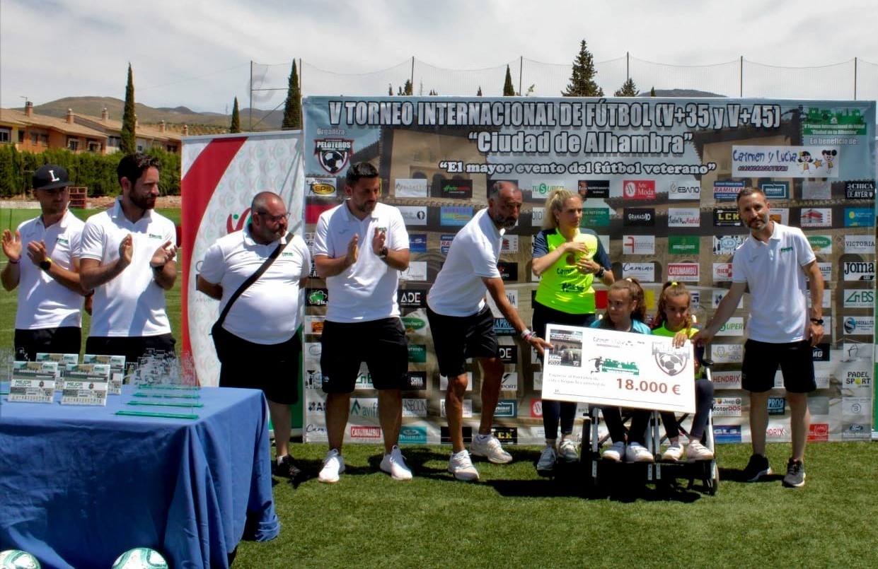 La entrega de los 18.000 euros de recaudación, en el campo de fútbol de Huétor Vega.