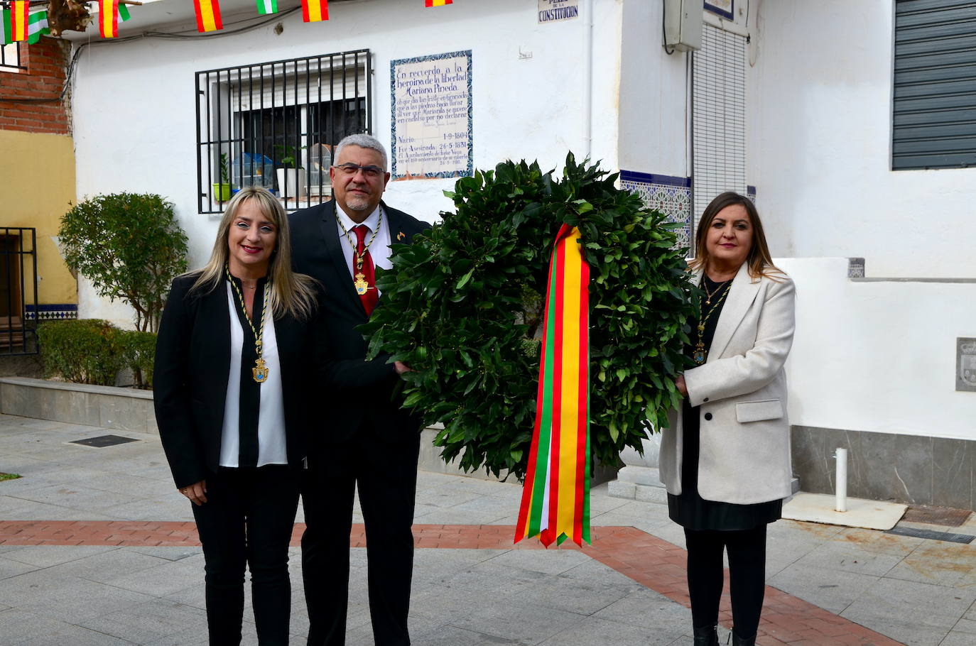 Portavoces de grupos municipales colocan la tradicional corona de laurel en la plaza de la Constitución.