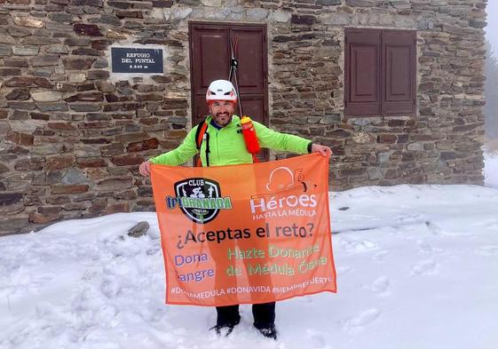 Antonio Luis Martín León muestra la bandera del reto en el Refugio del Puntal.