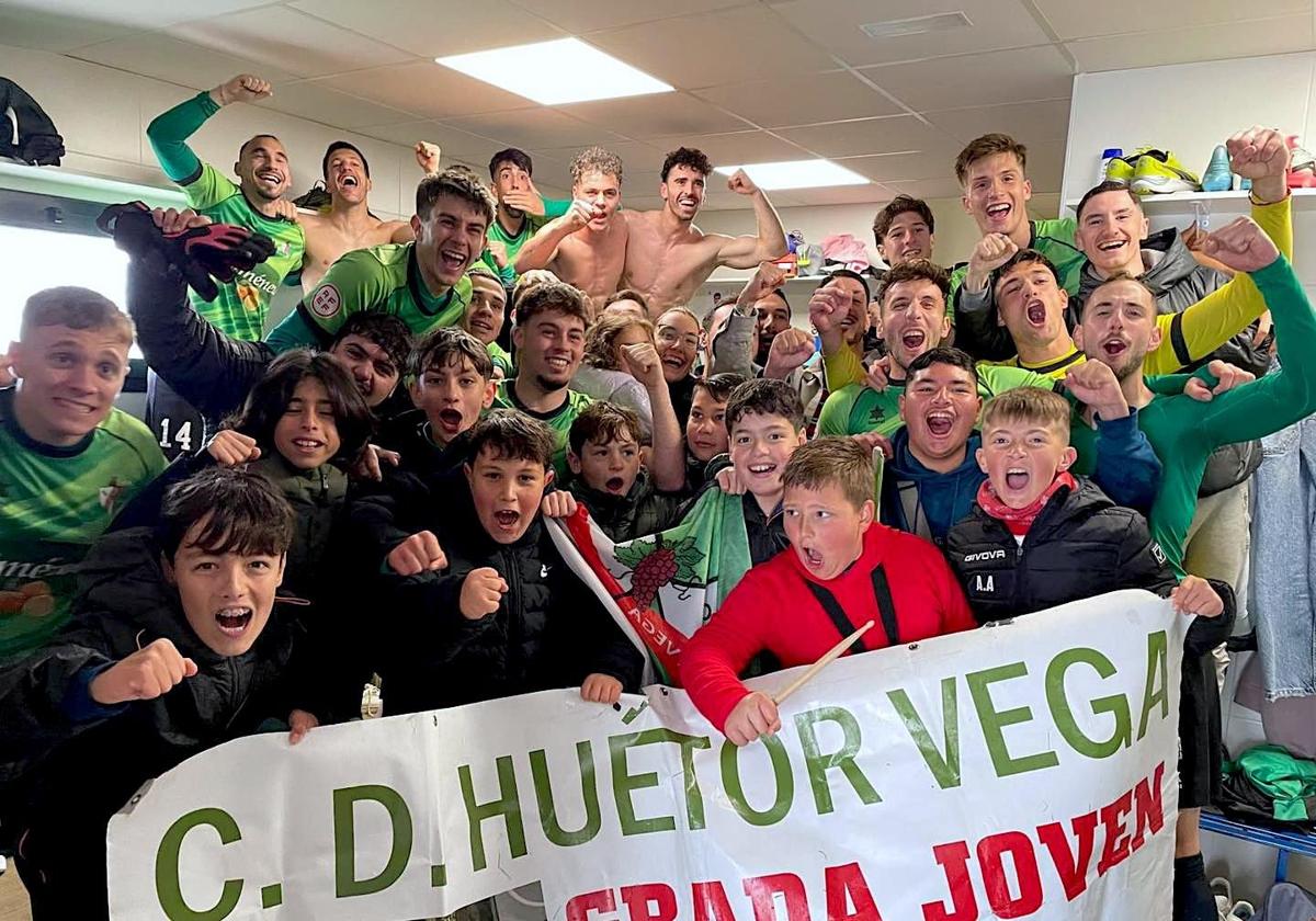 Los jugadores del CD Huétor Vega celebran la victoria con la Grada Joven en el vestuario.