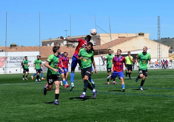 Pugna por un balón aéreo en el centro del campo con el visitante Torre del Mar, que es tercero.