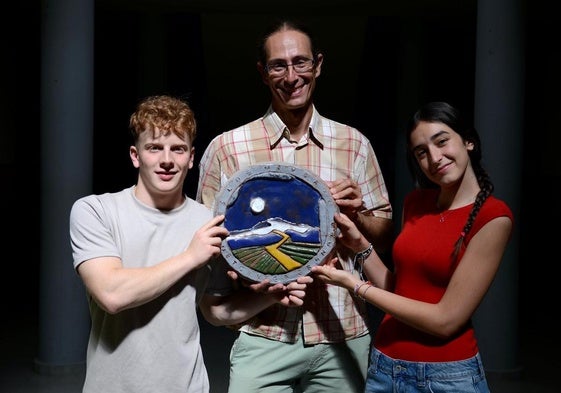 Sergio Burrell Gámiz y Aitana Cecilia Masmano Martínez sujetan el escudo del IES Los Neveros con José Cabrera Martos, jefe de Formación, Evacuación e Innovación Educativa.